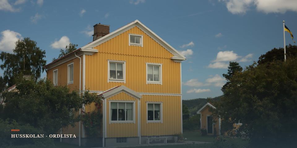 Gul trävilla där tak, fasad, fönster och grund syns tillsammans som husets yttre skal